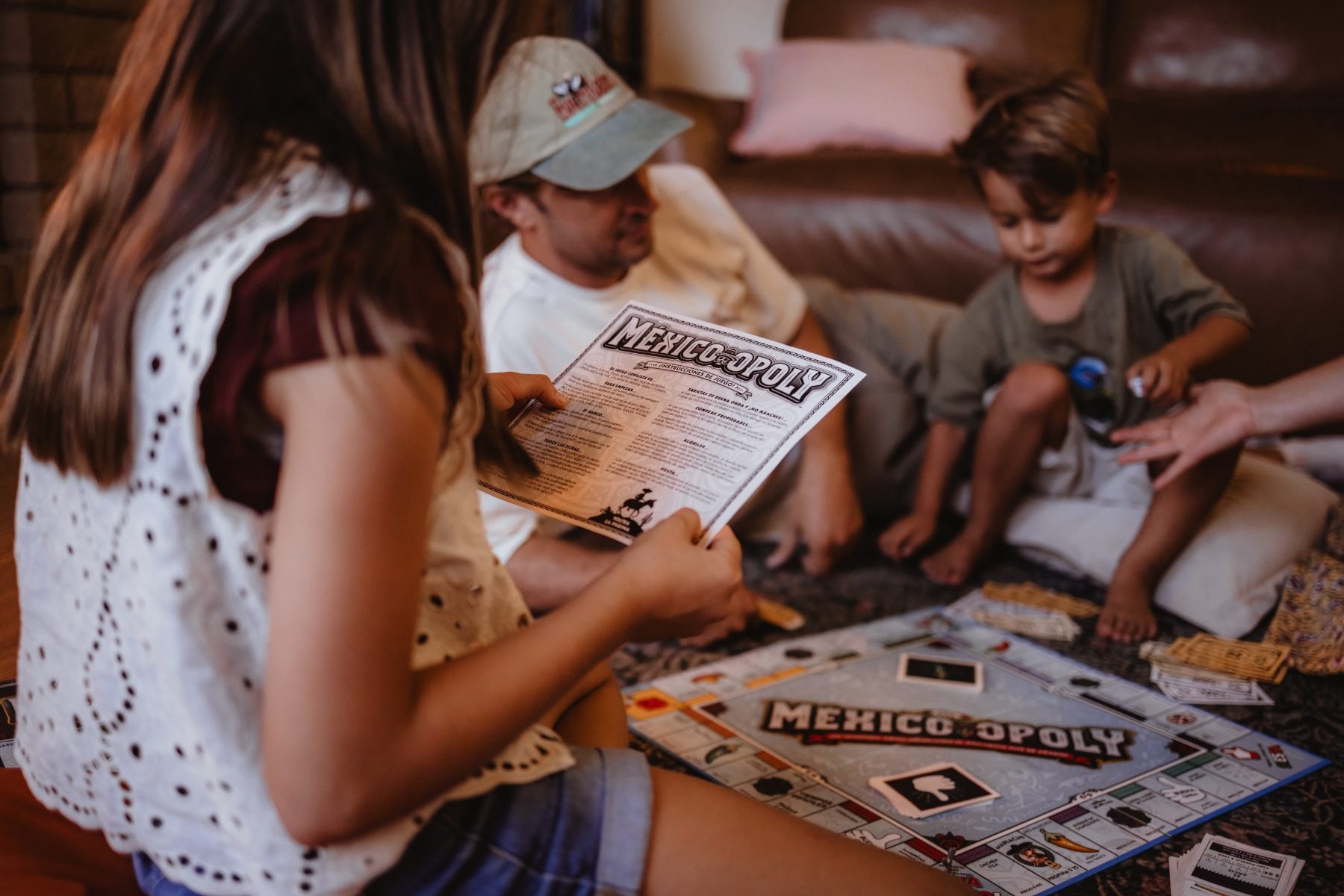 Family plays Mexico-opoly board game together on living room floor
