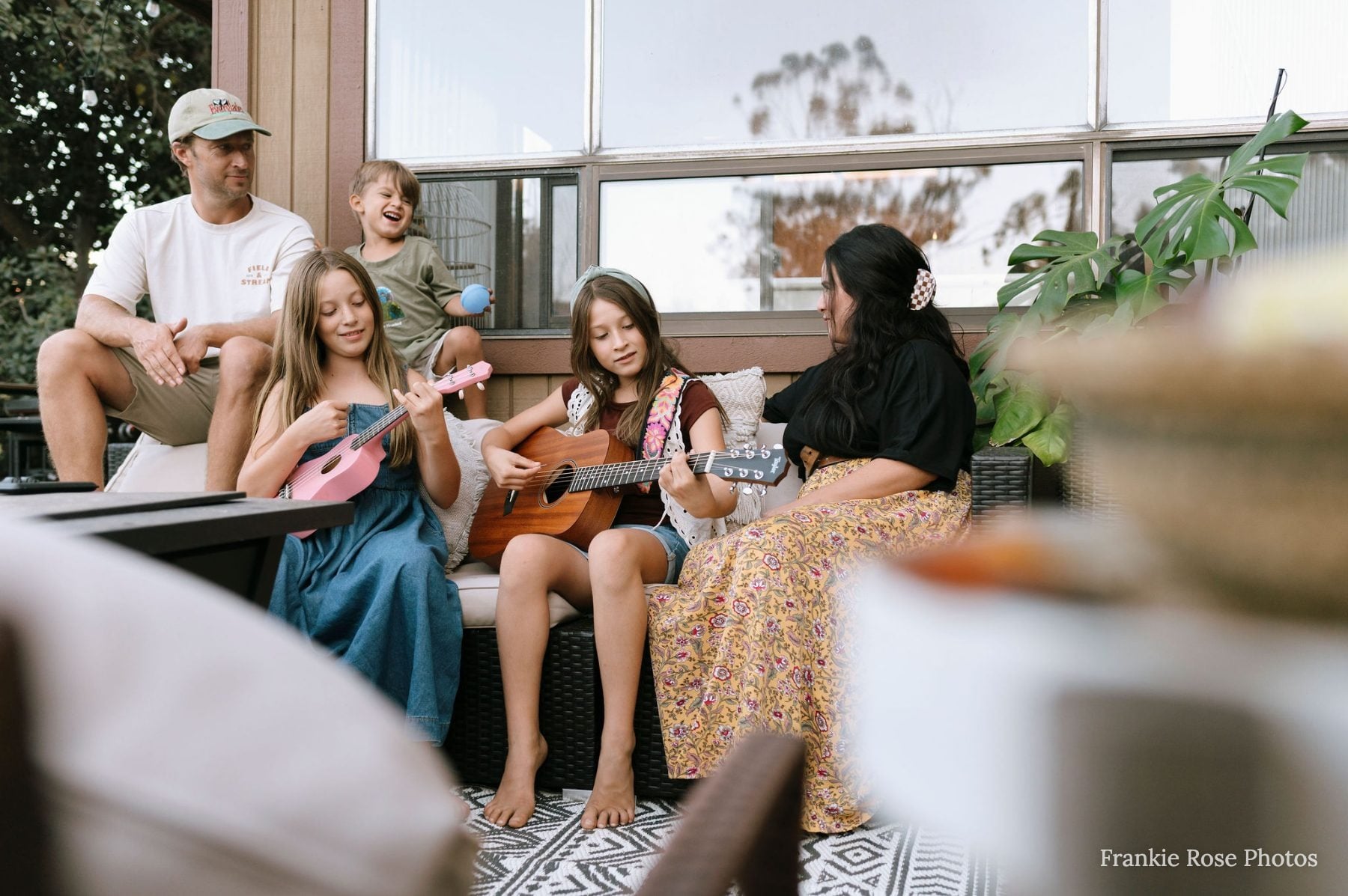 Family of five playing ukuleles together on porch in Lakeside, California