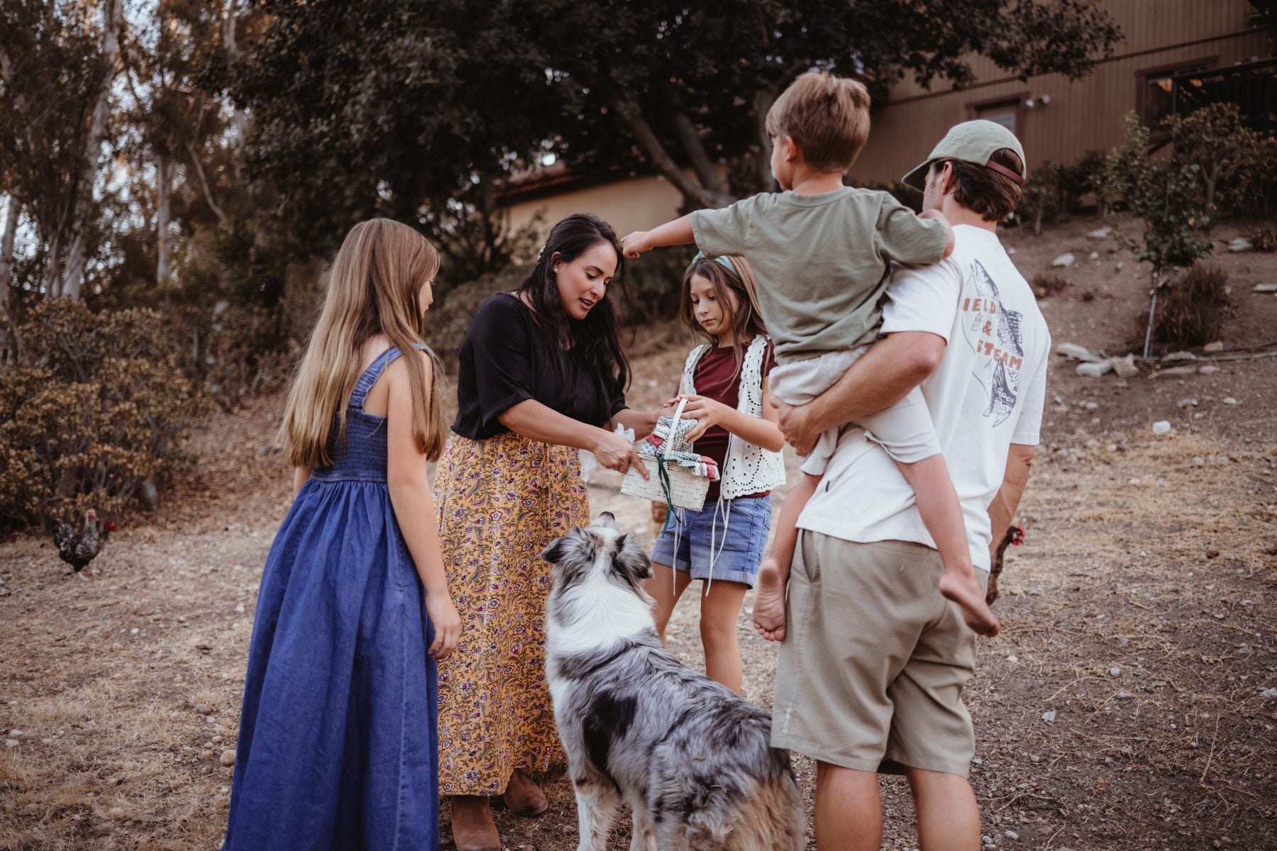 Family gathers around dog outdoors at their Lakeside, California home