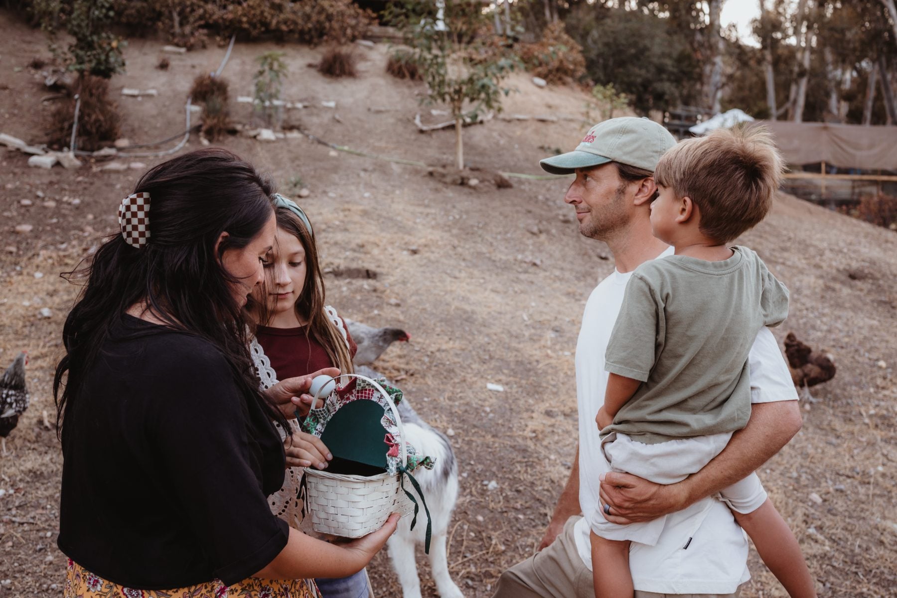 Family gathers with a goat and basket during backyard visit in Lakeside