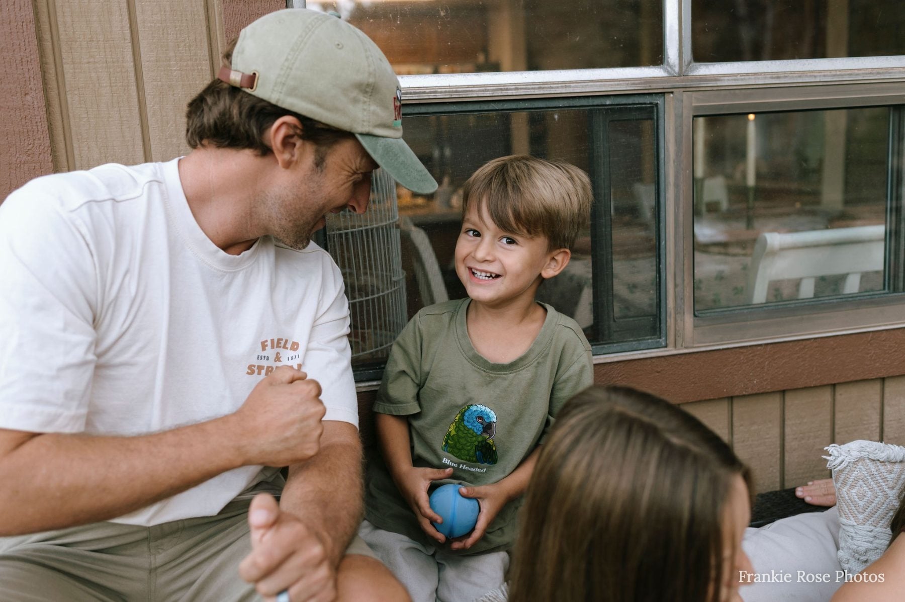 Dad and son share a laughing moment on the porch in Lakeside