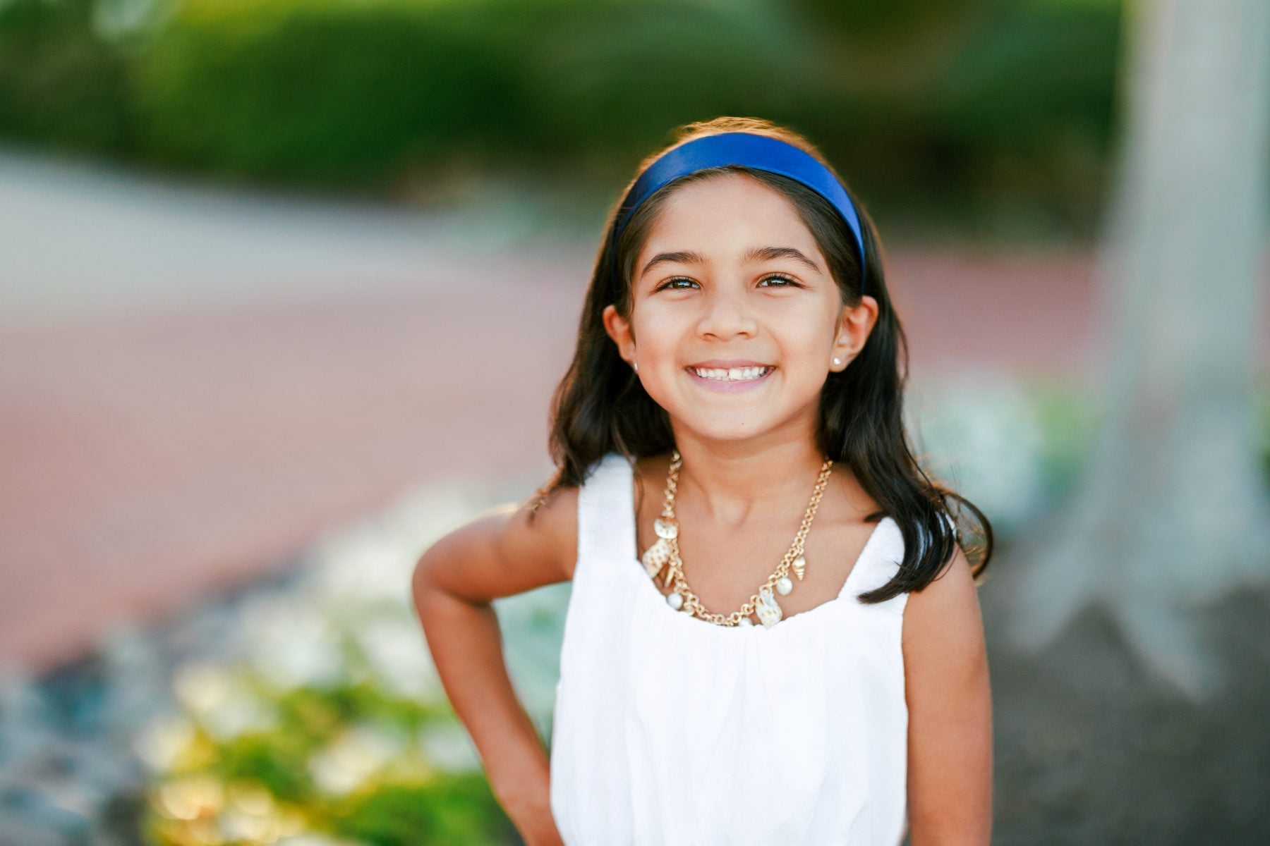 Smiling girl with blue headband poses for San Diego headshots