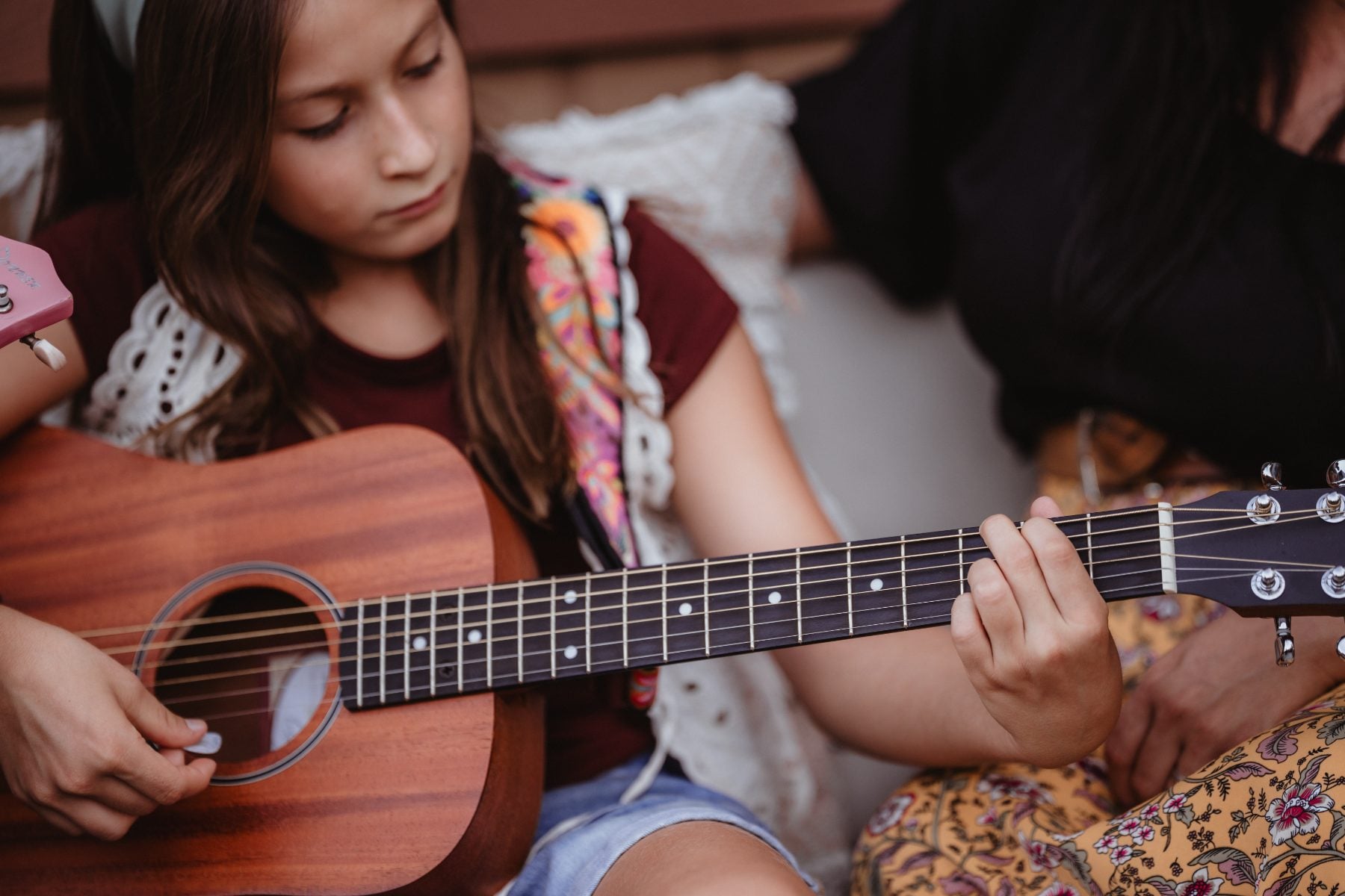 Girl practicing acoustic guitar during a family moment in Lakeside