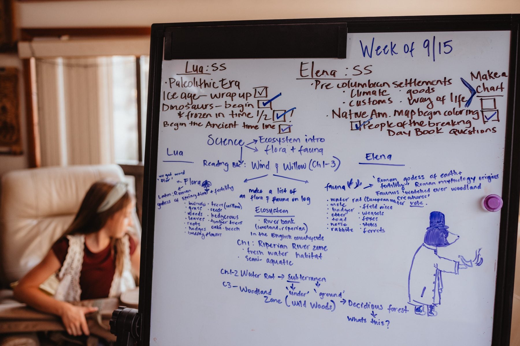 Girl studies at a homeschool whiteboard listing weekly lesson plans in Lakeside