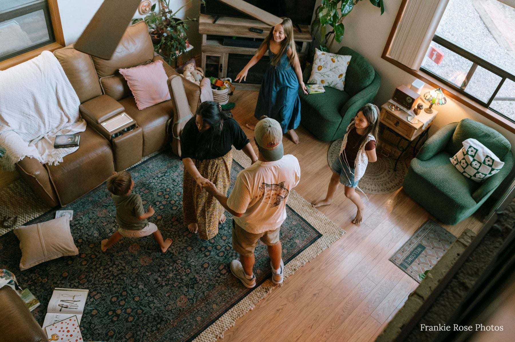 Overhead view of family dancing joyfully in Lakeside living room together