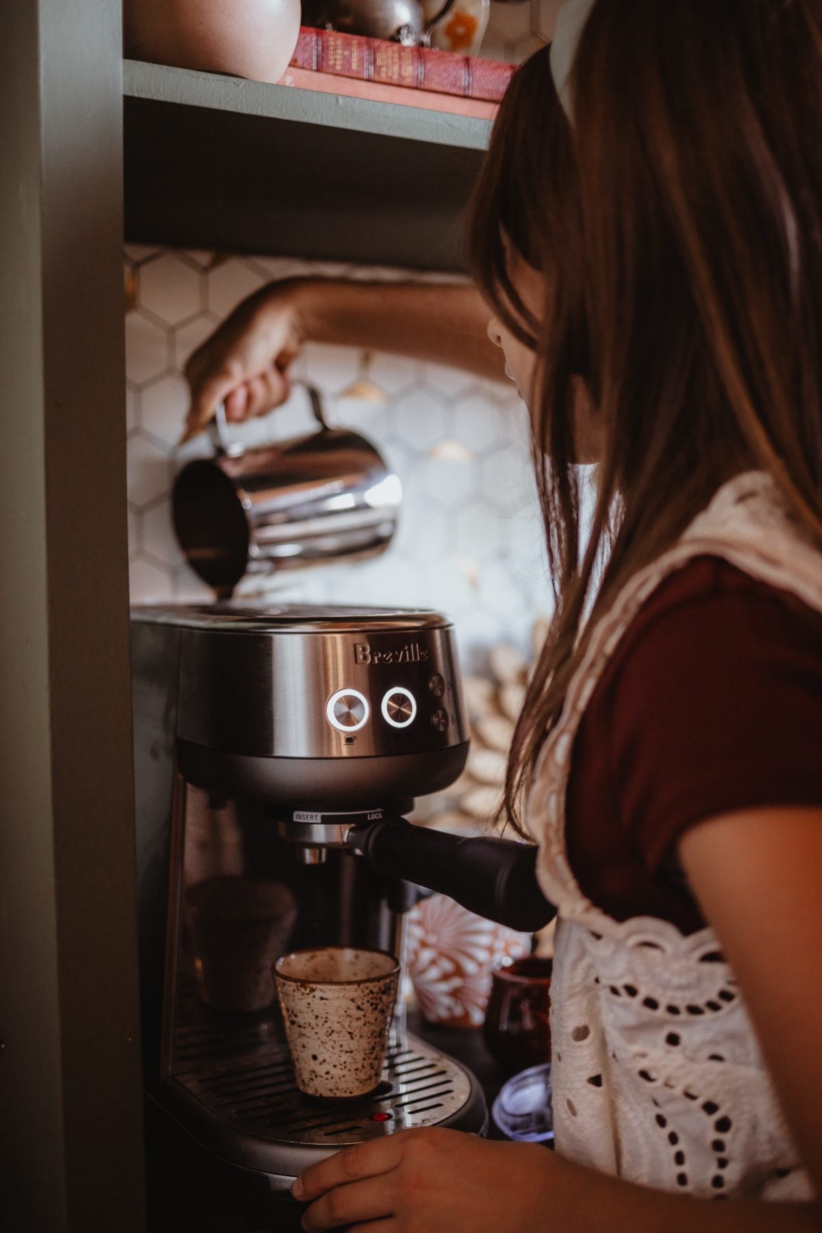 Girl steaming milk while making espresso in a Lakeside kitchen