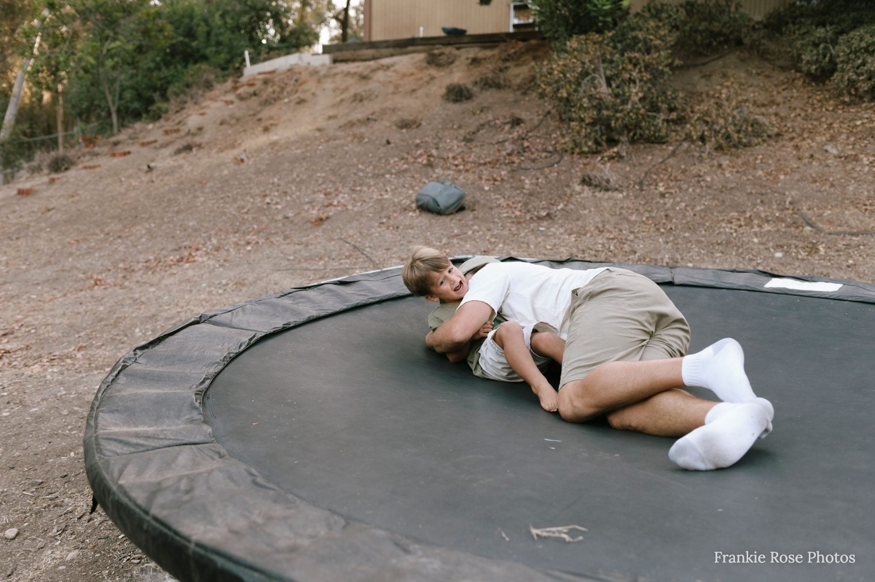 Man lying down and relaxing alone on a backyard trampoline