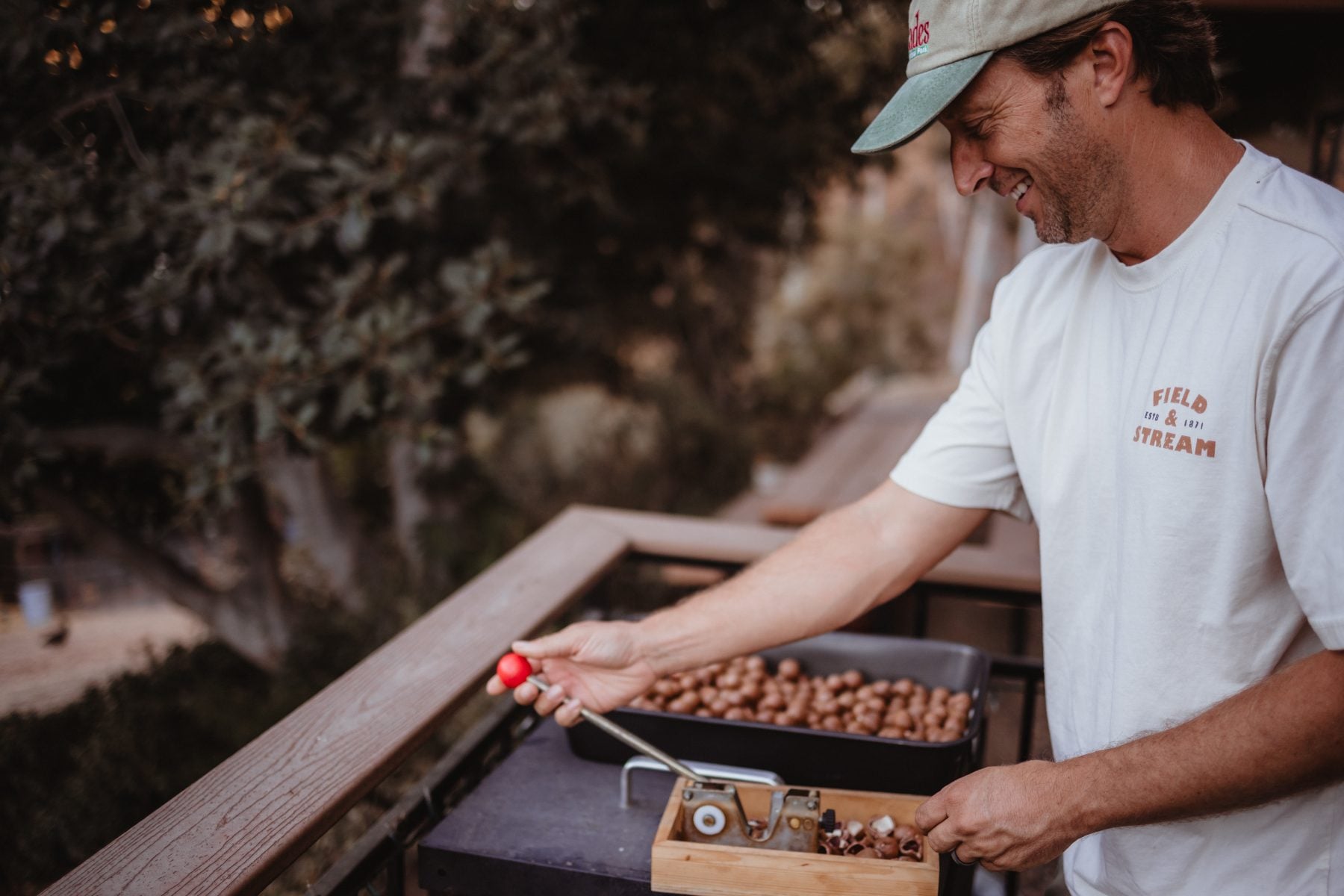 Man in cap shelling nuts on the deck of their Lakeside home