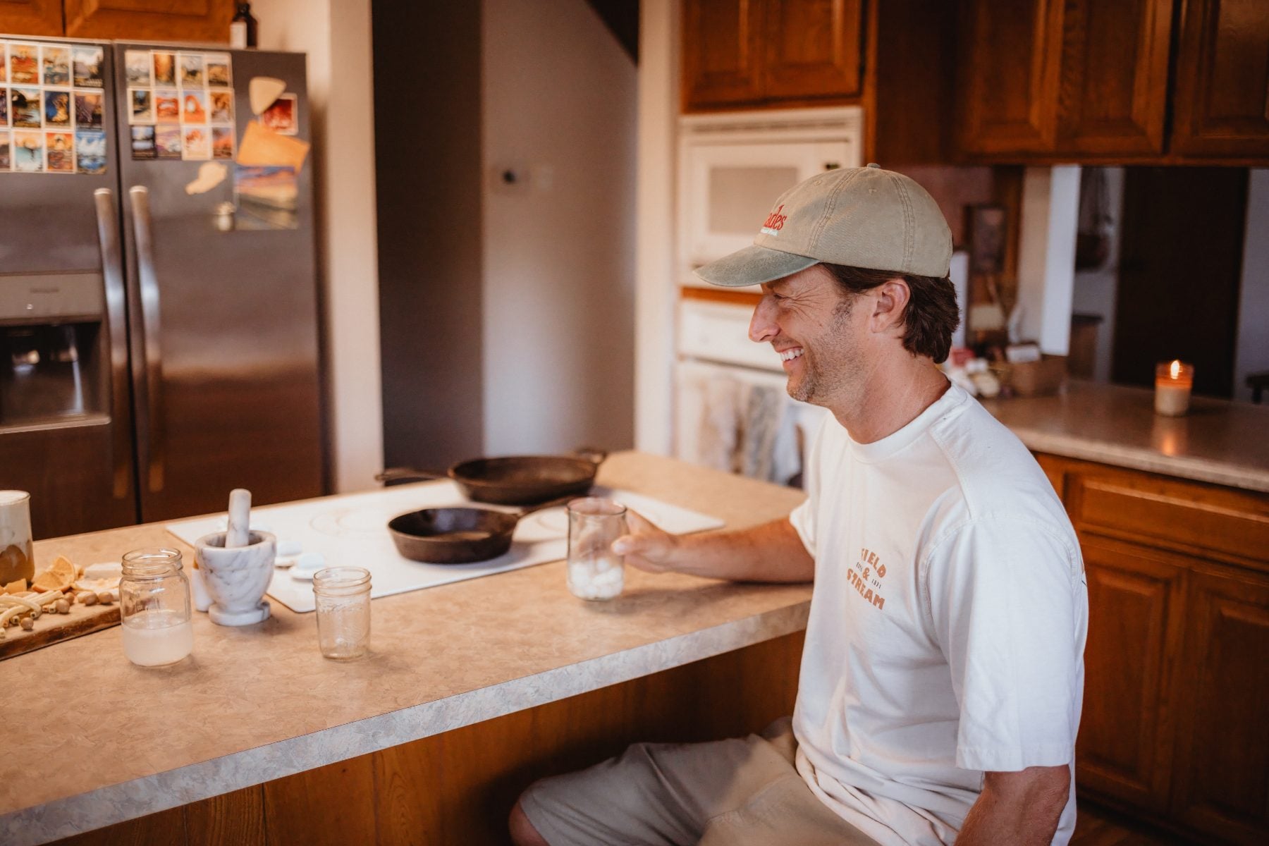 Man in cap smiling and chatting at kitchen counter in Lakeside