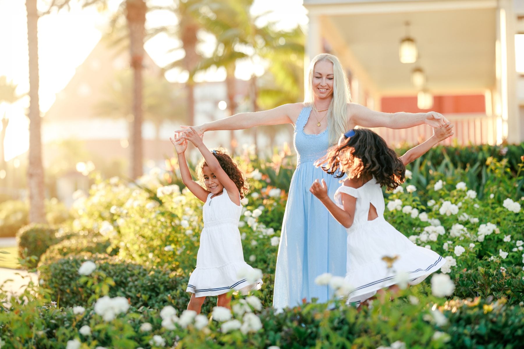 Mom spins her two daughters by the hands in garden