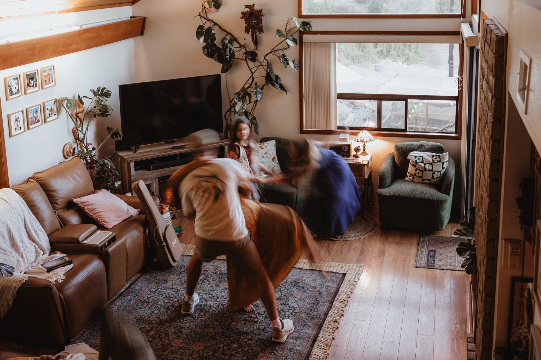 Blurred motion of mom and daughter dancing playfully in Lakeside living room