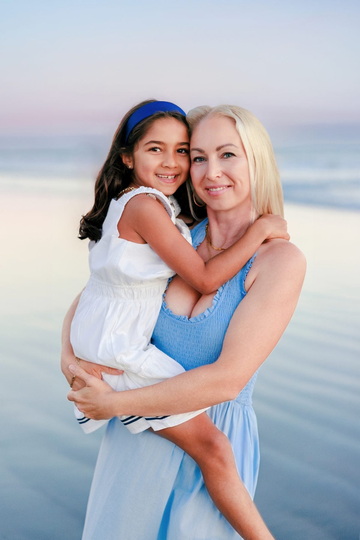 Mother embraces her daughter during a San Diego family photographer beach session
