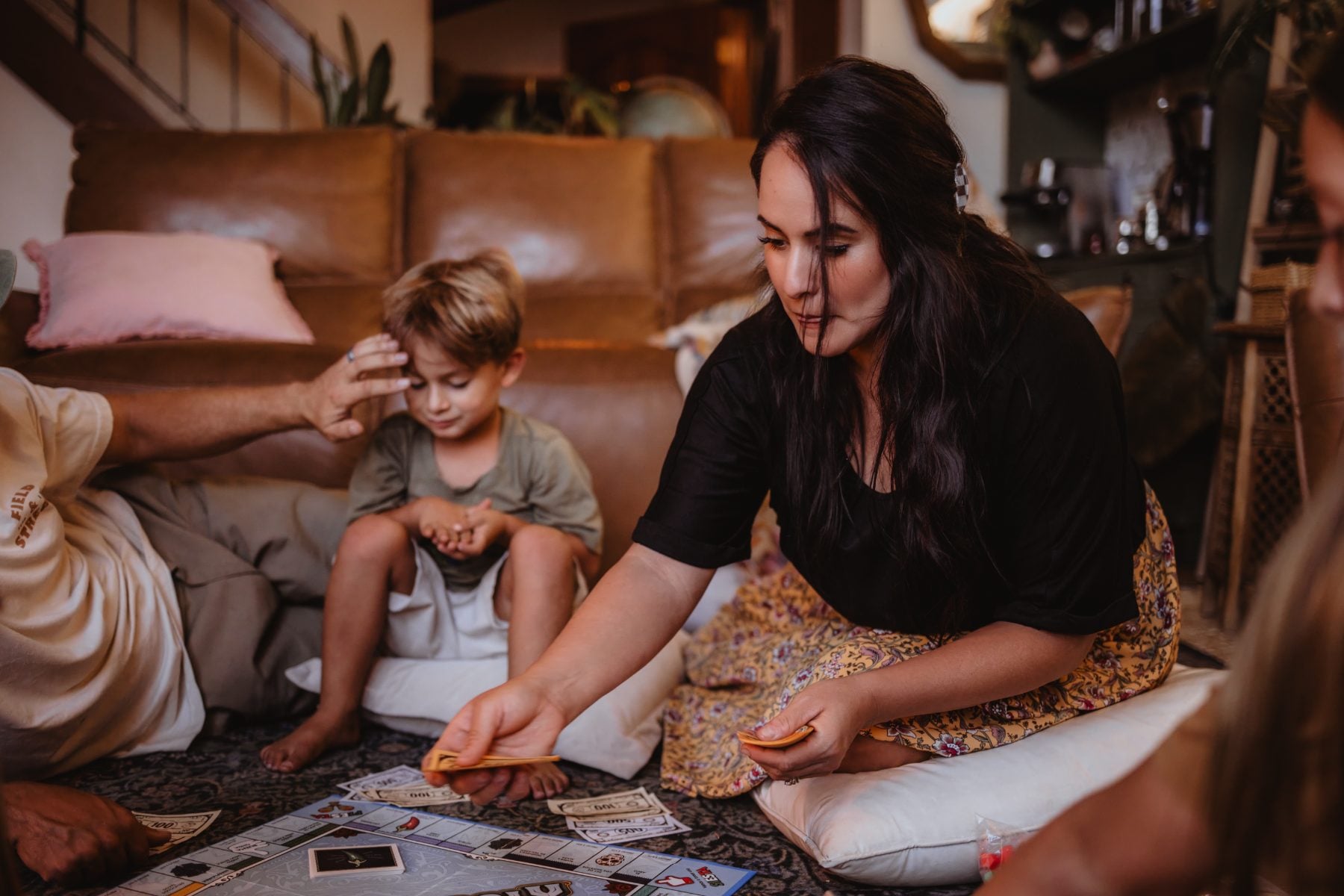 Mother places game piece while son watches on floor rug
