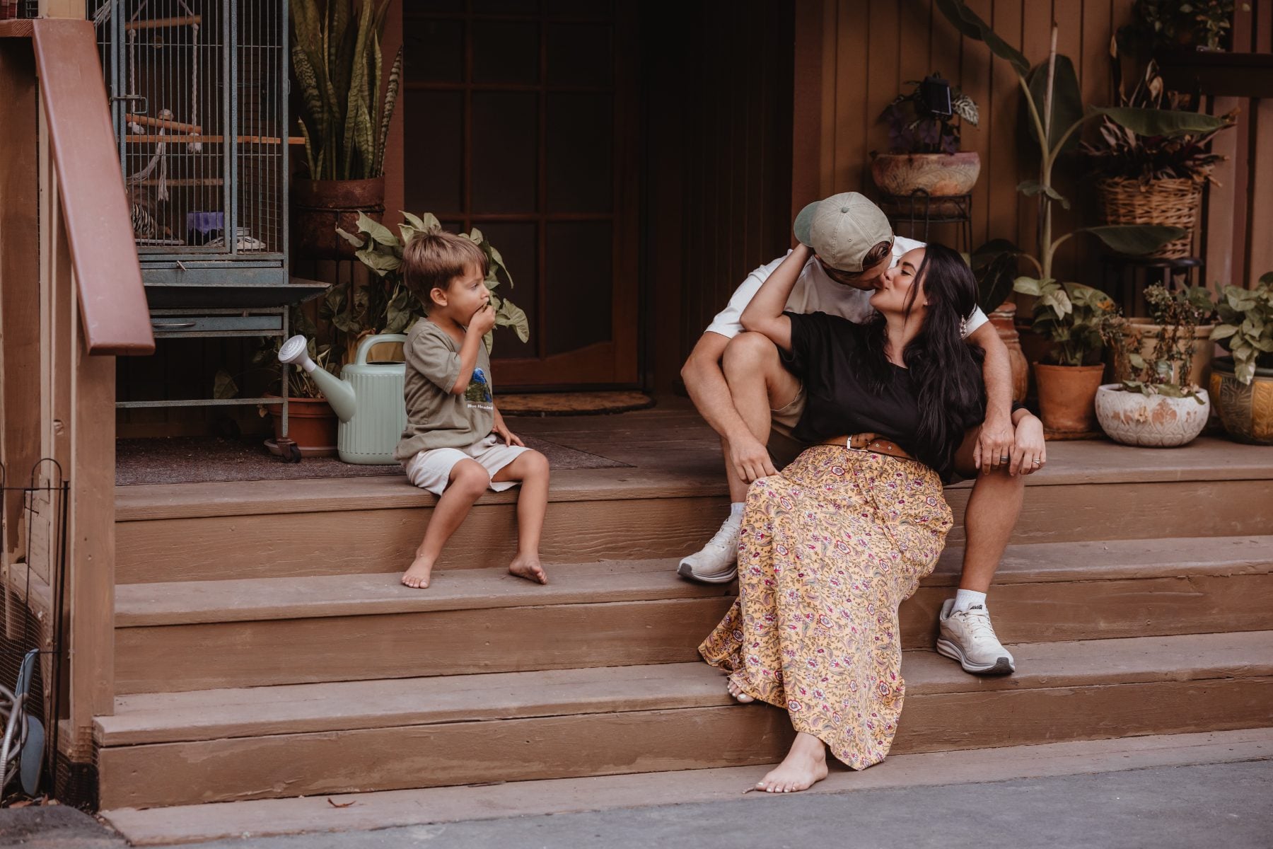 Mother laughs with sons on wooden porch steps in Lakeside