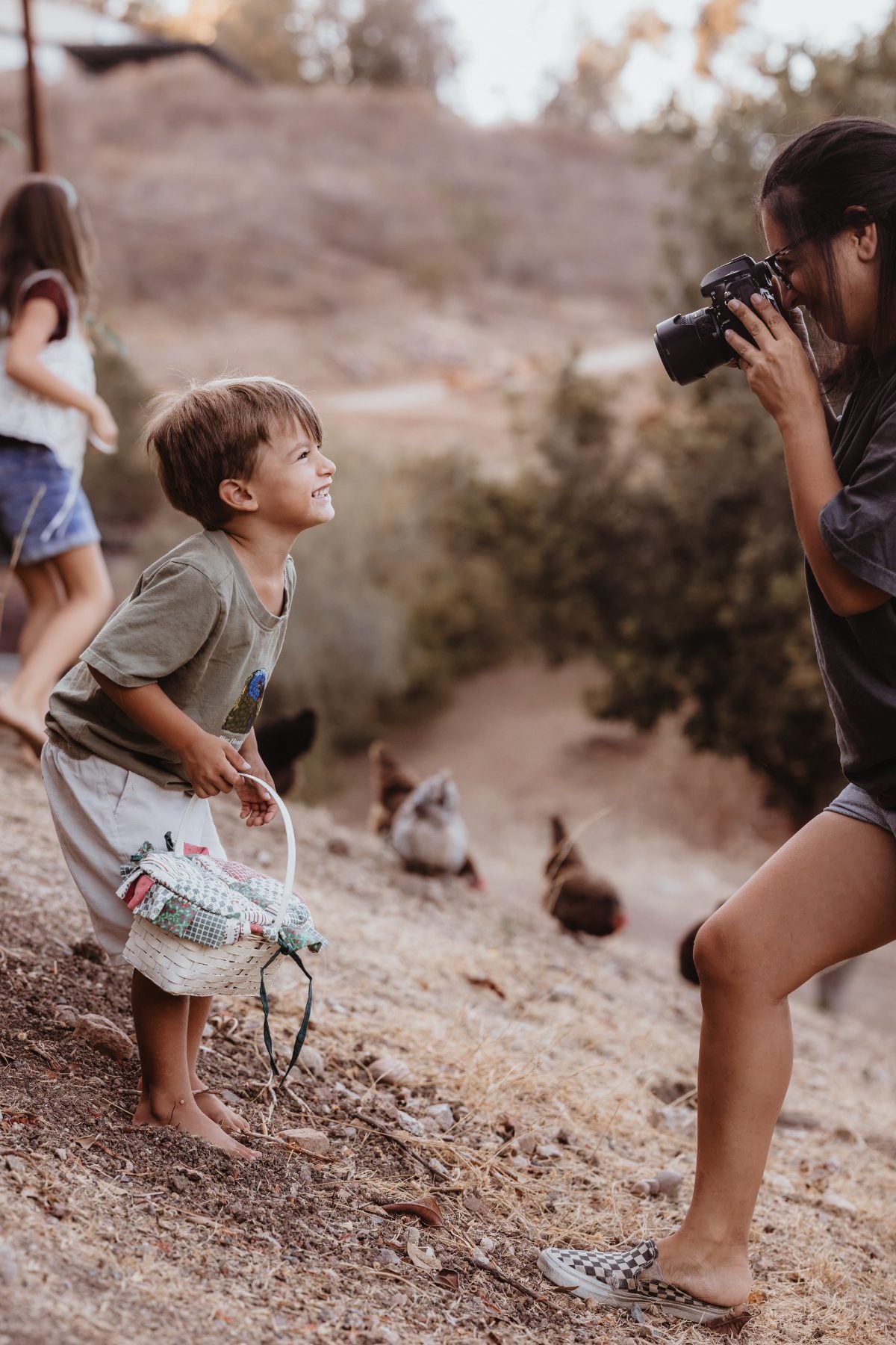 San Diego family photographer captures boy laughing near backyard chickens