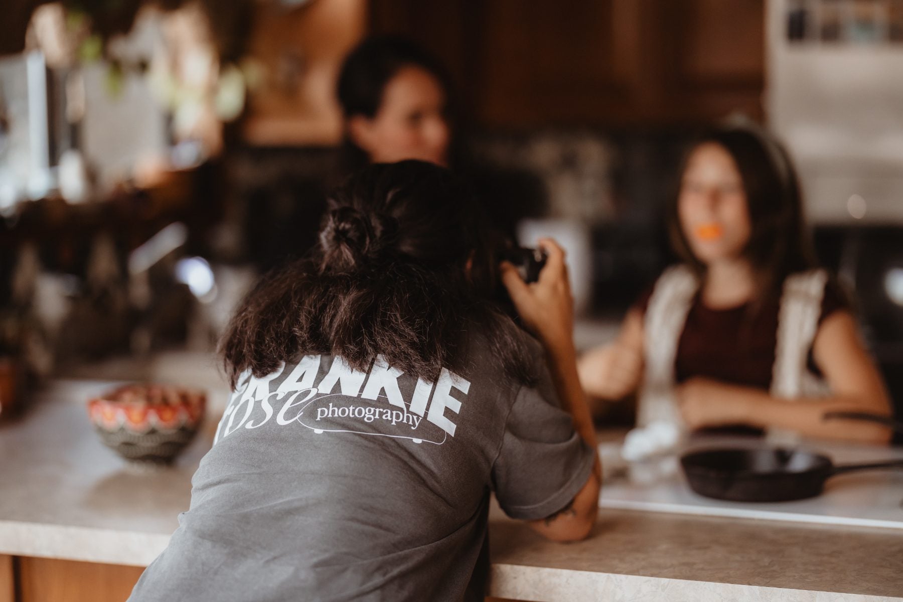 San Diego family photographer captures woman from behind in kitchen