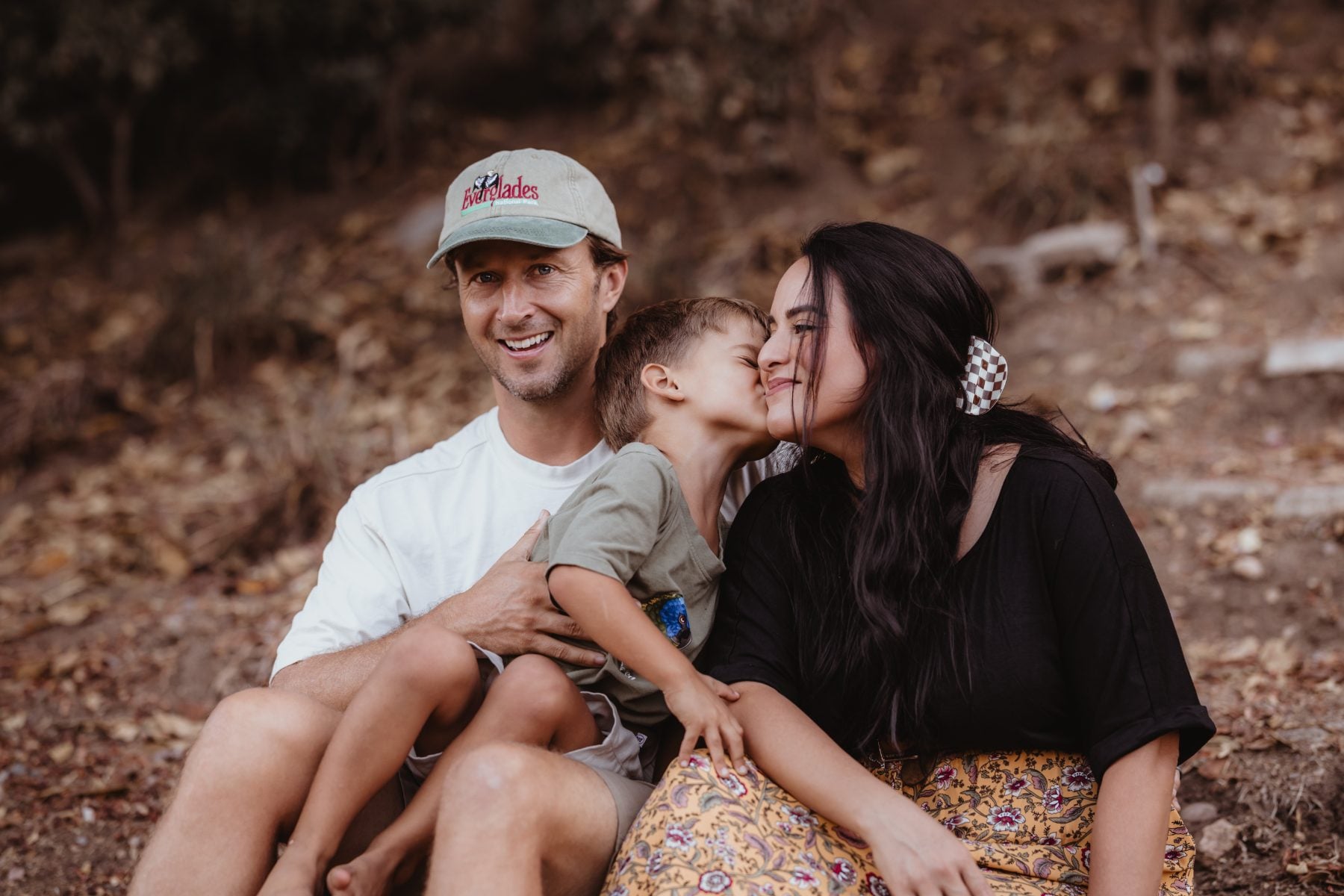 San Diego family photographer captures a child kissing mom's cheek outdoors