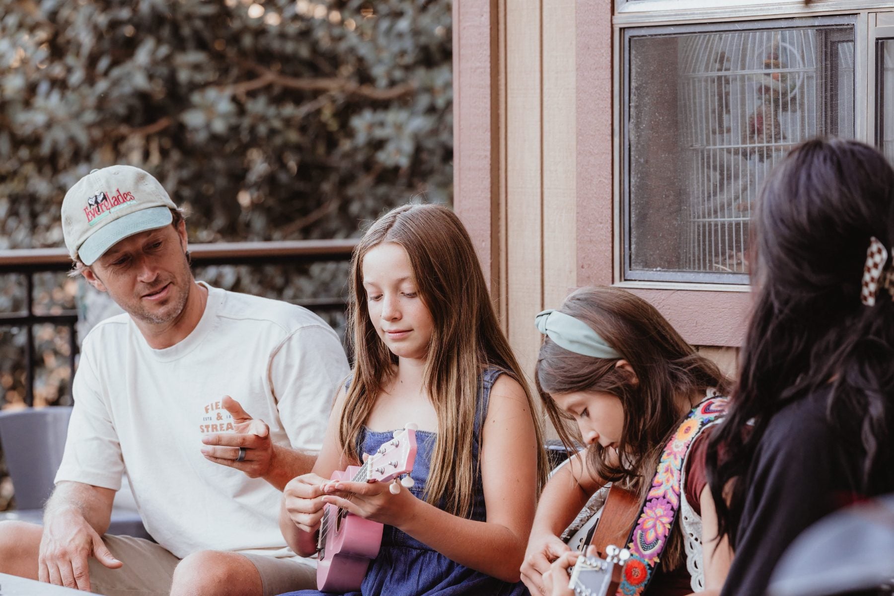 San Diego family photographer captures dad and daughters playing ukulele on porch