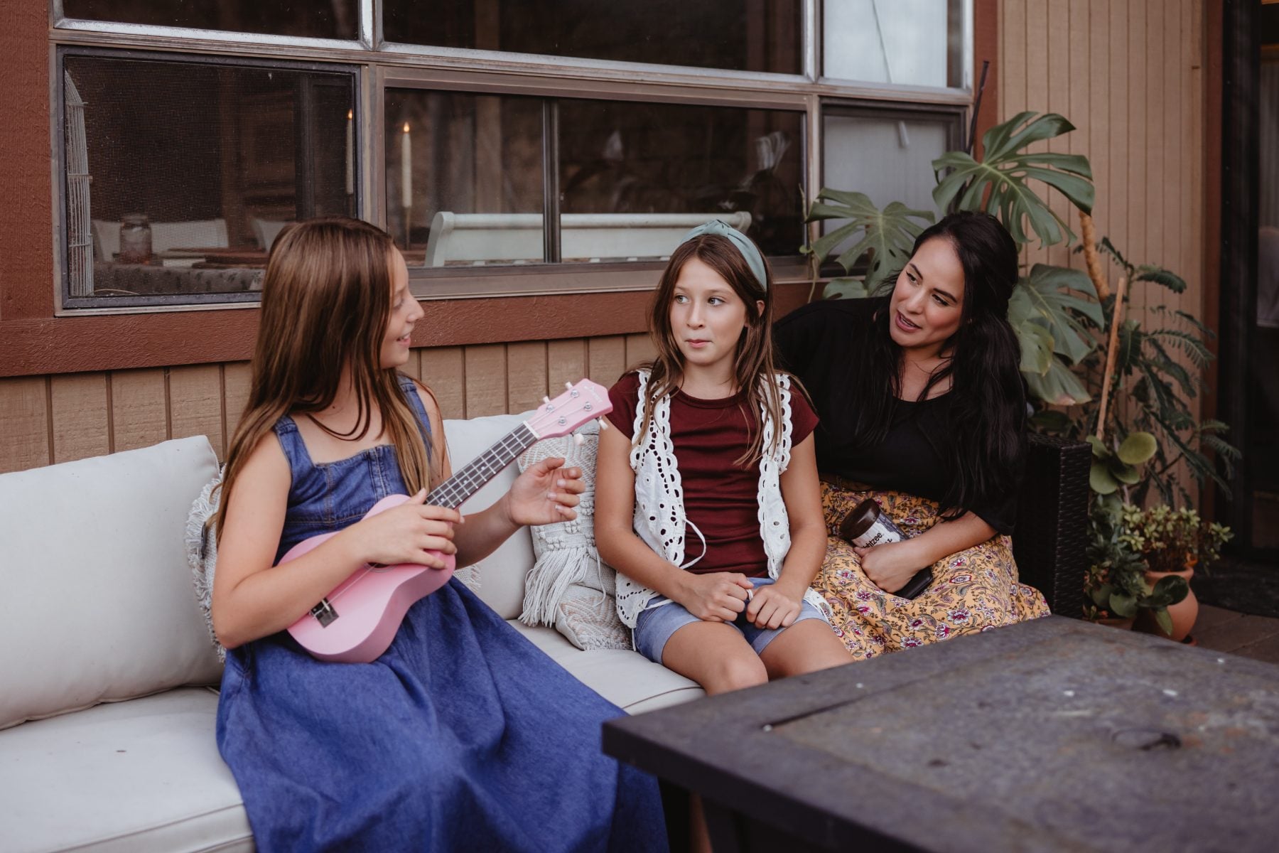 San Diego family photographer captures two girls and mom playing ukulele on the porch